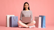 © Prostock-studio - Online Sales Concept. Cheerful Asian Lady With Laptop Sitting Among Shopping Bags