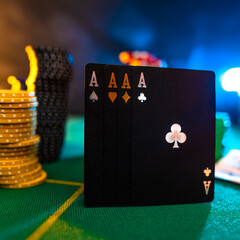 Black poker cards, four aces and chips on a green gambling table. Multicolored background. Concept - casino, online casino, gambling, poker, gambling business, night club, advertisement, banner.