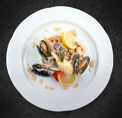 Wall Mural - Rice with seafood: shrimp, squid and mussels. Isolated on a black background.