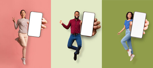 Happy excited asian women and african american man jumping from joy and showing phone with empty screen