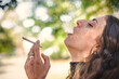 Closeup detail view of woman smoke marijuana ganja joint cigarette