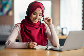 Wall Mural - Middle-eastern young lady student attending online webinar