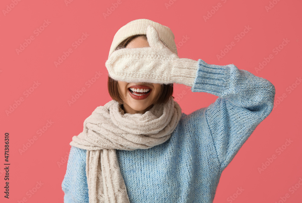 Happy young woman in stylish winter clothes on color background