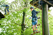© Irina Schmidt - Two children in forest adventure park. Kids boys in helmet climbs on high rope trail. Agility skills and climbing outdoor amusement center for children. Outdoors activity for kid and families.