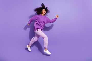Wall Mural - Full length profile photo of excited amazed girl running hurry look empty space isolated on purple color background