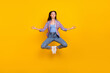 Leinwandbild Motiv Full length photo of peaceful serene lady jump meditate lotus pose wear plaid shirt isolated yellow color background