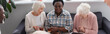© LIGHTFIELD STUDIOS - Positive interracial women with tea and digital tablet in nursing home, banner