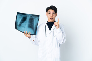 Poster - Young Chinese doctor man holding radiography isolated on white background intending to realizes the solution while lifting a finger up