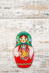 Girl, matreshka, woman in Russian national sundress and a kokoshnik with bouquet of flowers in hand on wooden background