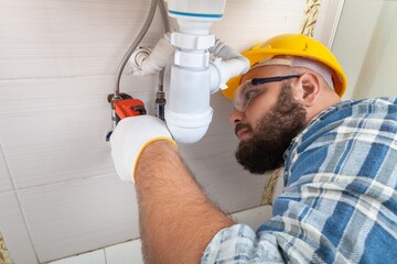 Wall Mural - Man plumber working in the bathroom, plumbing repair service, assemble and install concept.