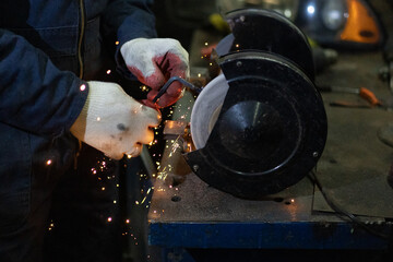 Man works with a circular saw. Sparks fly from the hot metal. Worker male person was working hard on steel. Slow motion in garage