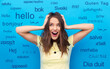 emotions, education and school concept - smiling young woman or teenage girl holding to her head or touching hair over greeting words in different foreign languages on blue background