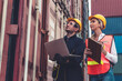 © InfiniteFlow - Industrial worker works with co-worker at overseas shipping container yard . Logistics supply chain management and international goods export concept .