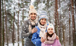 © Syda Productions - family, christmas and holidays concept - happy mother, father and little daughter in knitted hats and scarves over winter forest background