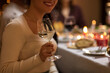 © Syda Productions - holidays, party and celebration concept - close up of happy smiling woman having christmas dinner at home and drinking white wine