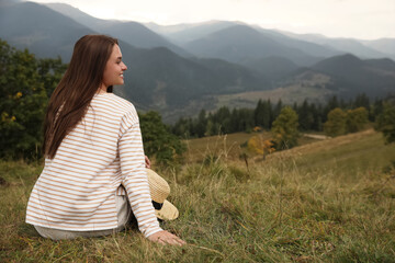 Poster - Young woman enjoying beautiful mountain landscape. Space for text