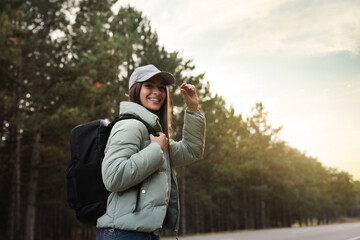 Wall Mural - Woman with backpack on road near forest