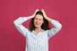 © New Africa - Mature woman suffering from headache on pink background