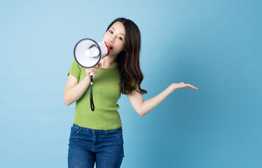 Wall Mural - Asian girl portrait holding speaker, isolated on blue background