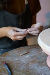 Poster - Female hands shaping details for pottery decor during art classes for leisure or education. Woman work with raw clay for entertainment or small business and handcraft potter production retail store