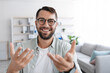 © Prostock-studio - Smiling emotional adult european male with beard in glasses looks at camera and shooting video for blog