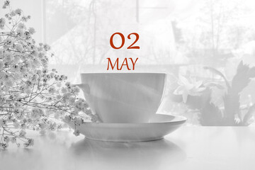 calendar date on light background with porcelain white tea pair and white gypsophila with copy space.  May 2 is the second  day of the month