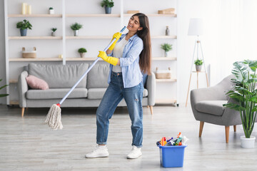 Wall Mural - Portrait of woman cleaning floor singing holding mop