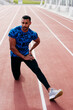 © ADDICTIVE STOCK - Athletic man stretching on the running track