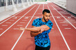 © ADDICTIVE STOCK - Athletic man stretching on the running track