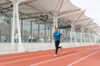 © ADDICTIVE STOCK - Athletic man running on the running track