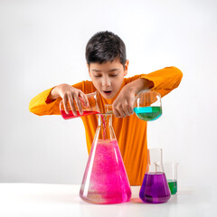 A schoolboy conducts experiments with a multi-colored liquid in flasks.