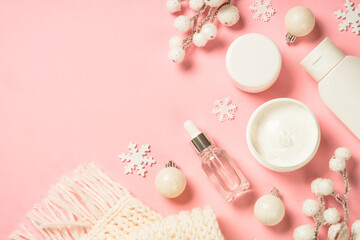 Wall Mural - winter cosmetic, skincare product. cream, serum, tonic with winter decorations. top view on pink bac