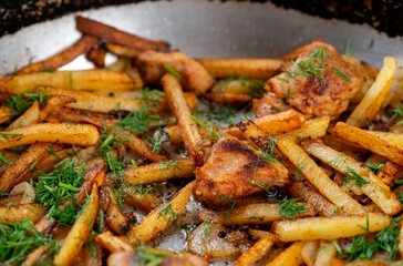 Roasted meat and potatoes in an iron pan