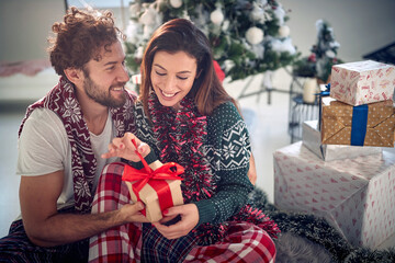 Wall Mural - Man and woman nicely wrapped exchanging Christmas gifts together