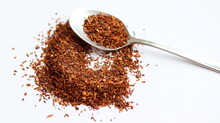 Rooibos Tea In Spoon, On White Background, On Table. Aspalathus Linearis. Loose Tea, Dry Leaves. Close Up.