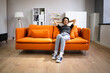 © Andrey Popov - Happy African Woman Relaxing On Sofa
