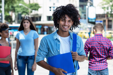 Laughing mexican male student with other young adults