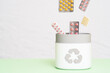 © vahit - Full of expired pills and medicines in the trash bin with recycling symbol. Waste management concept.