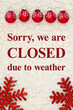 Closed due to weather sign with red snowflakes ornaments on beige sherpa