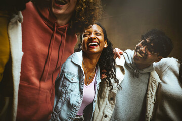 Wall Mural - Happy young people laughing together - Multiracial friends group having fun on city street - Mixed race students hanging out together -Friendship, community, youth, university concept