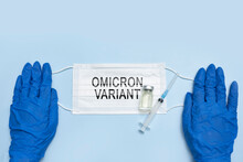 Female Doctor Holds A Face Mask With - Omicron Variant Text On It. Covid-19 New Variant - Omicron. Omicron Variant Of Coronavirus. SARS-CoV-2 Variant Of Concern