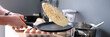 Male chef tossing pancake in frying pan in kitchen closeup