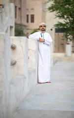 Wall Mural - Arab man looking at the sunrise in the alleys of al seef district in Dubai