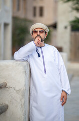 Wall Mural - Arab man looking at the sunrise in the alleys of al seef district in Dubai