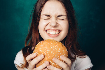 Wall Mural - woman eating hamburger fast food snack close-up