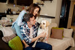 © Maria - Young couple and their fluffy baby labrador retriever at home in the kitchen