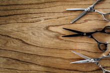 Top View Of Barber Scissors Over Wooden Table. Barbershop Background With Copy Space.