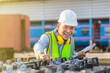 © JU.STOCKER - Engineer in waistcoats and hardhats with documents inspecting construction site, Smiling mechanical worker checking of the battery storage system