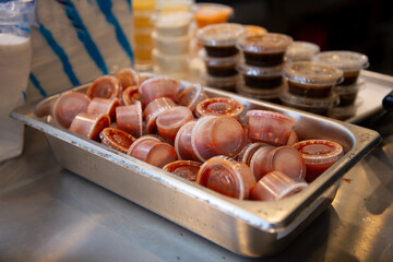 Wall Mural - A view of a tub full of customer ready condiment cups of sauce, seen at a local restaurant.