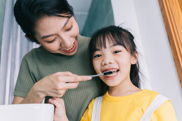 Wall Mural - Mother and daughter brush their teeth together.